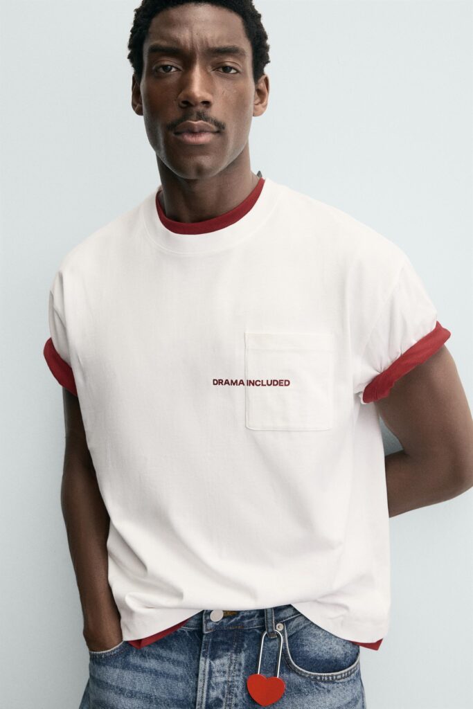 White t-shirt featuring red text statement graphic on upper back placement.